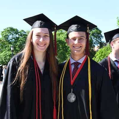 Graduates in cap and gown posing for a photo